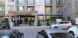 eine Stadtstraße mit Autos vor einem Geschäft in der Unterkunft Жилой комплекс Мээрим in Bischkek + 2 Fotos