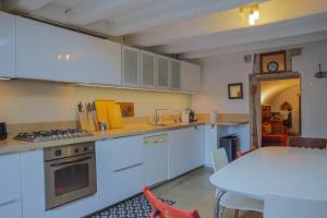 uma cozinha com armários brancos e uma mesa branca e uma mesa em Galerie Nakai Art B&B em Tournus