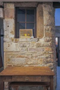 a stone wall with a window and a wooden bench at Galerie Nakai Art B&B in Tournus +27 photos