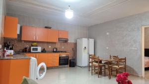 Una cocina con refrigerador y una mesa y sillas. en appartement luxe, en Berkane