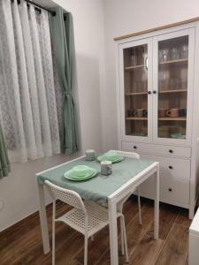 a dining room table with two chairs and a white cabinet at La Ginestra in Bastia