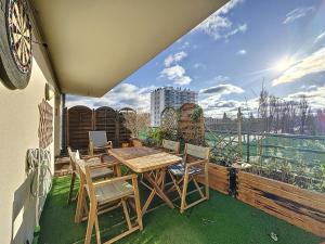 eine Terrasse mit Tisch und Stühlen auf einem Balkon in der Unterkunft Duplex Prestige 5p RER Paris 15 min in Joinville-le-Pont