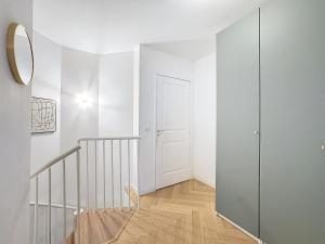 ein weißes Zimmer mit einer Treppe und einer Tür in der Unterkunft Duplex Prestige 5p RER Paris 15 min in Joinville-le-Pont