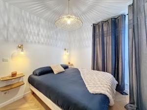 ein Schlafzimmer mit einem blauen Bett und einem Kronleuchter in der Unterkunft Duplex Prestige 5p RER Paris 15 min in Joinville-le-Pont + 3 Fotos