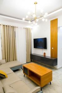 a living room with a couch and a tv at Nzuri Nest Keza in Kigali