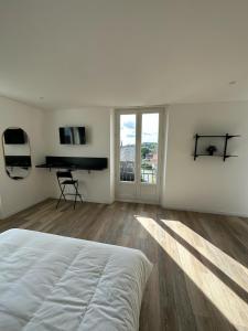 a white bedroom with a bed and a piano at Bright luxury apartment 26 in Hirson