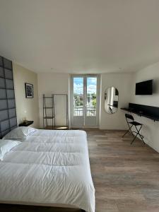 a bedroom with a large white bed and a desk at Bright luxury apartment 26 in Hirson