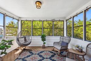 eine abgeschirmte Veranda mit Stühlen und Fenstern in der Unterkunft 1009 - Land's End in Corolla