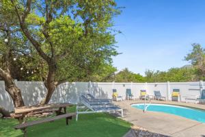 Ein Pool mit einer Bank und Stühlen neben einem Zaun in der Unterkunft 1009 - Land's End in Corolla