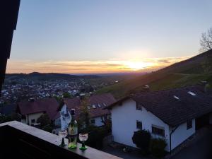 une vue du coucher de soleil depuis une maison avec des verres à vin dans l'établissement Ferienwohnung Kappelblick, à Kappelrodeck 4 autres photos