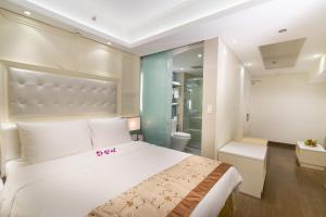 a bedroom with a large white bed and a bathroom at Empress Hotel Ho Chi Minh City in Ho Chi Minh City +68 photos