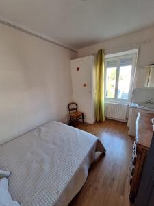 ein Schlafzimmer mit Bett und eine Küche mit Fenster in der Unterkunft La Saint-Mametoise in Saint-Mamet