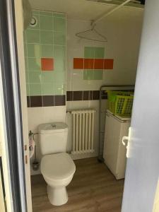 une salle de bain avec des toilettes blanches et un radiateur dans l'établissement La Saint-Mametoise, à Saint-Mamet