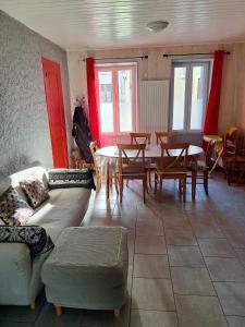 ein Wohnzimmer mit einer Couch und einem Tisch und Stühlen in der Unterkunft La Saint-Mametoise in Saint-Mamet