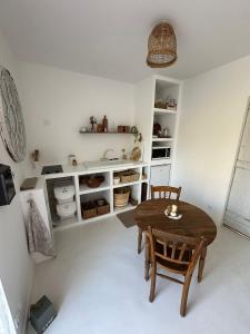 a kitchen with a table and chairs in a room at La Casita in Maisoncelles-du-Maine