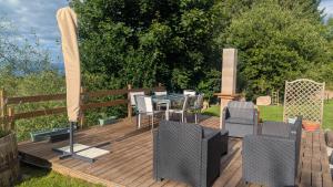 eine Holzterrasse mit einem Tisch und Stühlen darauf in der Unterkunft Domaine de la Griffe - Appartement "Sous Dine" in La Roche-sur-Foron + 36 Fotos