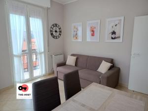 a living room with a couch and a clock on the wall at Vimodrone, modern accommodation near San Raffaele in Vimodrone
