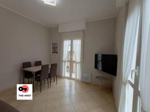 a living room with a dining room table and a television at Vimodrone, modern accommodation near San Raffaele in Vimodrone
