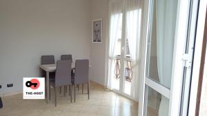 a dining room with a table and chairs with a sign at Vimodrone, modern accommodation near San Raffaele in Vimodrone
