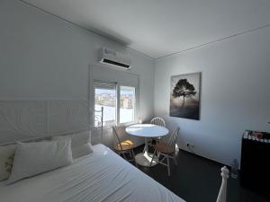 ein Schlafzimmer mit einem Bett und einem Tisch und einem Fenster in der Unterkunft Krezias Apartments K1 Acropolis View! in Athen