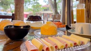 a table with sandwiches and oranges and orange juice at Pousada Maken Hary - Centro in Arraial d'Ajuda