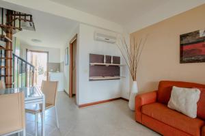 - un salon avec un canapé orange et une table dans l'établissement Residence Cernaia - Private Cottage, à Castiglione della Pescaia