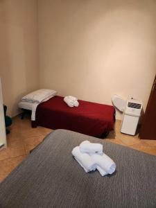 zwei Betten in einem Zimmer mit Handtüchern auf dem Boden in der Unterkunft Bed to the Future Parma in Parma