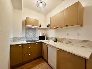 a kitchen with brown cabinets and a white counter top at Appartement neuf 4 prsn Au cœur du Centre Ville in Besançon