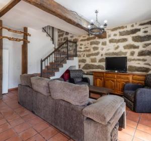 a living room with a couch and a tv at La Bodega de Gredos in Navaluenga