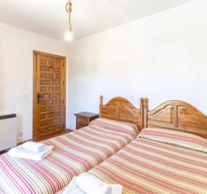 a bedroom with a bed with a striped blanket at La Bodega de Gredos in Navaluenga
