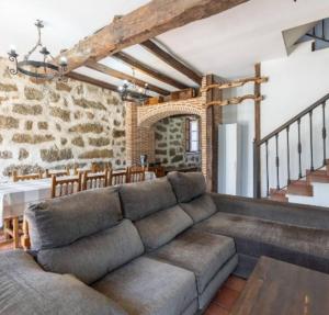 a living room with a couch and a stone wall at La Bodega de Gredos in Navaluenga
