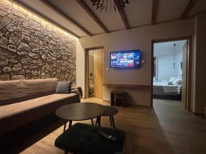 a living room with a couch and a table at Tzovolos Apartments in Kalavrita +37 photos