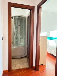 Una puerta de cristal que da a una habitación con un dormitorio. en MYHOUSE INN RACCONIGI - Affitti Brevi Italia, en Turín