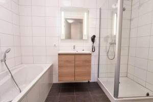 une salle de bain avec une baignoire, un lavabo et une douche dans l'établissement Hello Zeeland - Wijngaardstraat 29, à Domburg 1 autre photo