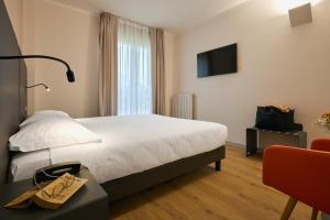 una habitación de hotel con una cama y un televisor en Zenit Park Hotel, en Rivalta di Torino