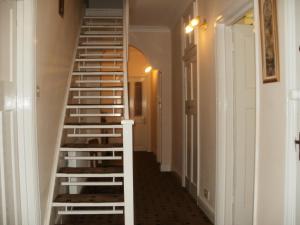 una escalera de caracol en un pasillo con una barandilla blanca en London Heathrow Guesthouse, en Hillingdon