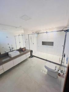 une salle de bains blanche avec toilettes et lavabo dans l'établissement Casa em Pedra Azul, à Pedra Azul