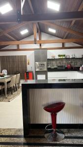 eine Küche mit einer Bar mit einem roten Hocker in der Unterkunft Casa em Pedra Azul in Pedra Azul + 8 Fotos