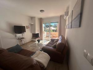 ein Wohnzimmer mit Sofa und Fernseher in der Unterkunft Lovely apartment see views,pool and garden,Resort in Fuengirola