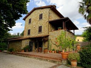 an old stone house with a patio in front of it at Casa Dina in Terontola