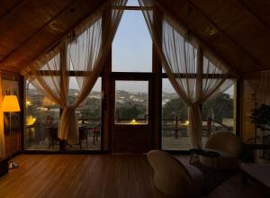 ein Wohnzimmer mit einer großen Glastür mit Aussicht in der Unterkunft كاف كوخ in Sawdāʼ