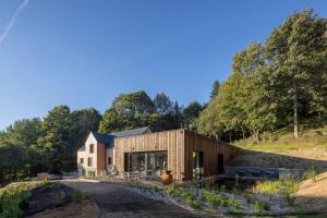 une maison arborée sur le flanc d'une colline dans l'établissement Apartmány Hraničná s privátním wellness, à Bedřichov