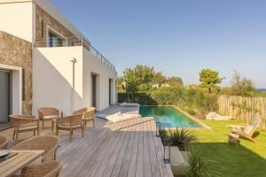 a backyard with a swimming pool and a wooden deck at Villa Yaya in Cervione