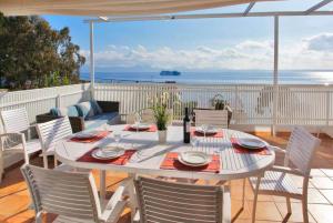 ein Tisch und Stühle auf einer Terrasse mit Blick auf das Meer in der Unterkunft Villa Maria de Bonaire in Alcanada