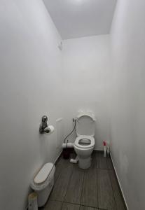 a white bathroom with a toilet and a sink at Face au Métro 14, Chambre avec balcon et vue sur jardin, 5 min Orly, 7 min Paris in Chevilly-Larue +9 photos