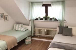 ein kleines Schlafzimmer mit zwei Betten und einem Fenster in der Unterkunft L21-Apartment Alsdorf, 3 Zimmer, 4 Betten, Standardisierte Ausstattung, ideal für Reisende, Pendler, Familien in Alsdorf