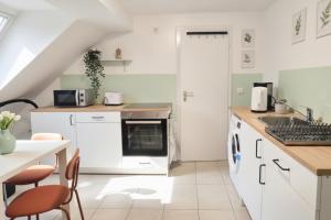 eine Küche mit weißen Schränken und einem Tisch und Stühlen in der Unterkunft L21-Apartment Alsdorf, 3 Zimmer, 4 Betten, Standardisierte Ausstattung, ideal für Reisende, Pendler, Familien in Alsdorf