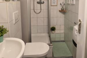 ein Badezimmer mit Dusche, Toilette und Waschbecken in der Unterkunft L21-Apartment Alsdorf, 3 Zimmer, 4 Betten, Standardisierte Ausstattung, ideal für Reisende, Pendler, Familien in Alsdorf