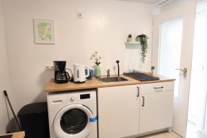 eine Küche mit Waschmaschine und Spüle in der Unterkunft L21-Apartment Alsdorf, 3 Zimmer, 4 Betten, Standardisierte Ausstattung, ideal für Reisende, Pendler, Familien in Alsdorf