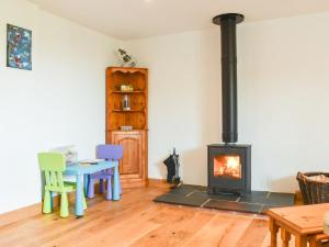 a living room with a stove and a table and chairs at Slade Barn - Uk42977 in Highbray